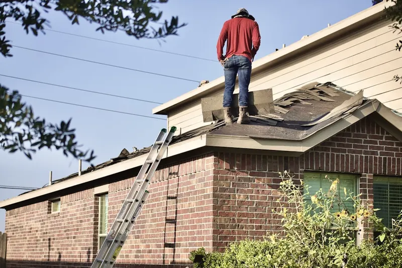 Professional roofer working on a residential roof in Stelton